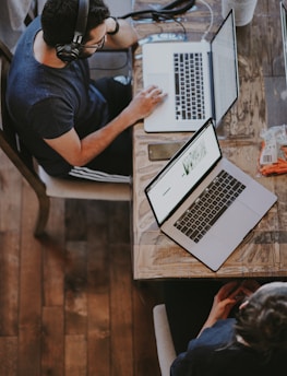man sitting on chair and looking laptop computer