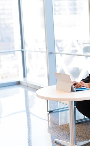 woman sits of sofa while using tablet computer