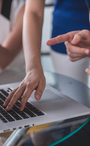 person touching and pointing MacBook Pro