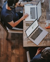 man sitting on chair and looking laptop computer